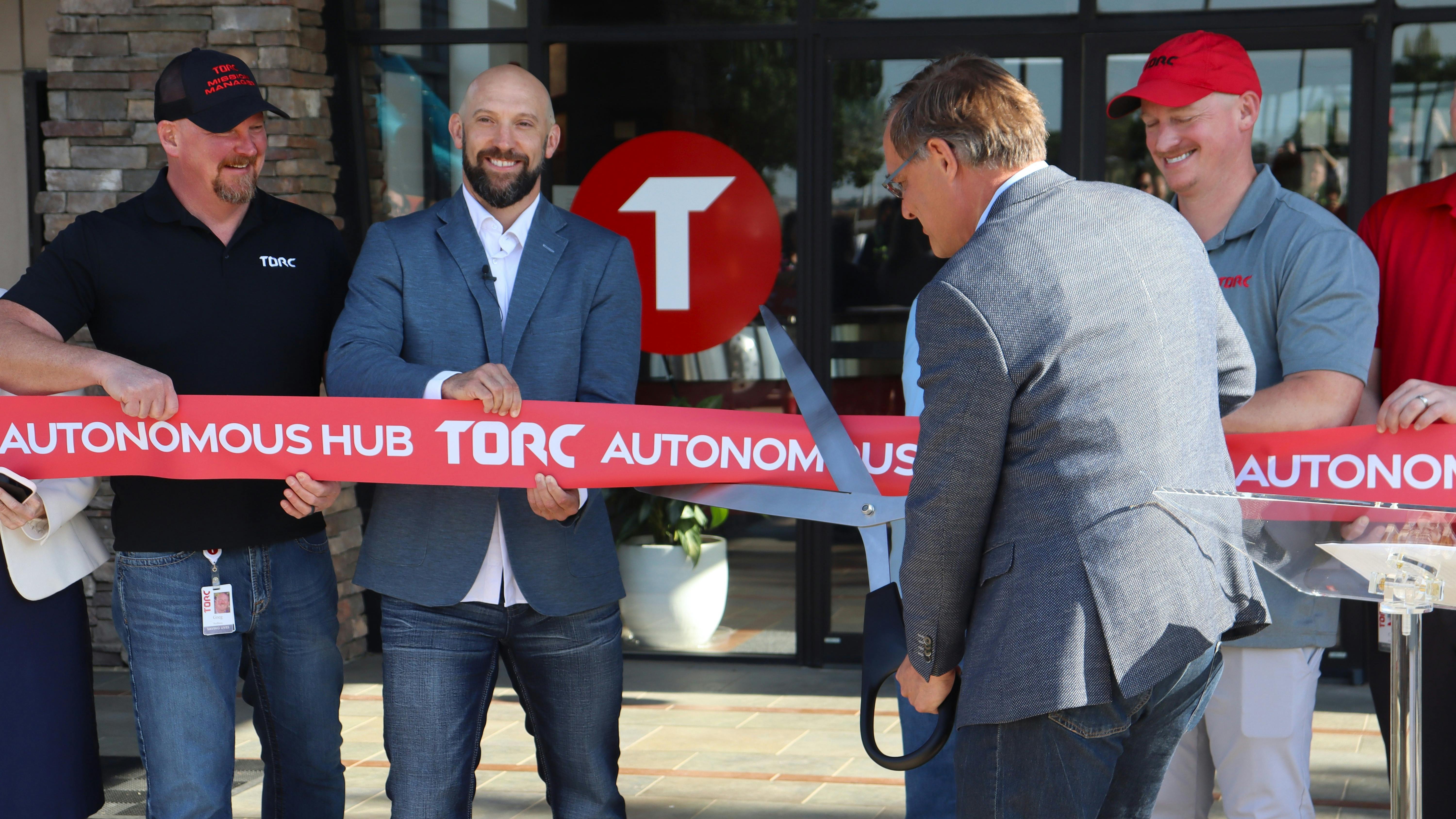 Torc CEO Peter Schmidt cuts a ceremonial ribbon during the official grand opening of the company's first autonomous trucking hub in Fort Worth, Texas.