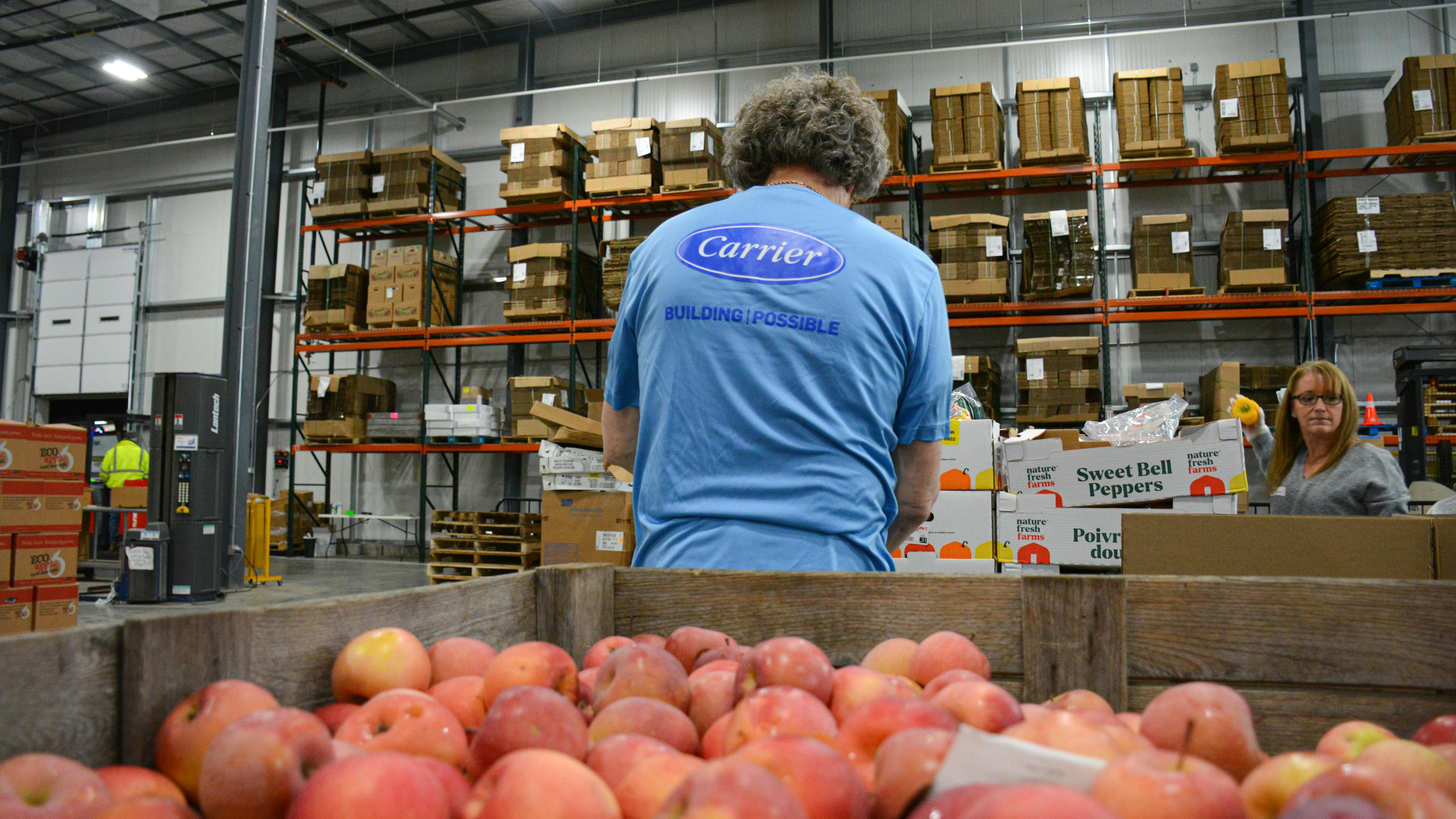 6841b041f9ad63b2c5a50ed4 A Carrier Employee Volunteers At The Food Bank Of