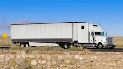 Semi truck traveling over flat, rocky road Semi truck traveling over flat, rocky road