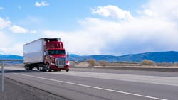 Red semi-truck hauling a refrigerated trailer on an open highway with mountains in the background, representing long-haul trucking and freight transport. Red semi-truck hauling a refrigerated trailer on an open highway with mountains in the background, representing long-haul trucking and freight transport.