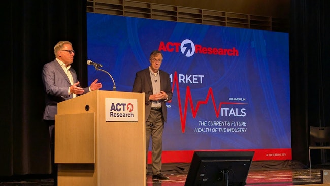 ACT Research President Ken Vieth, left, pays tribute to Jim Meil, a longtime industry analyst who plans to retire this year. He's been a principal with ACT Research for more than a decade after a long career as an Eaton economist.