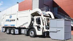 Heil front-end loader garbage truck collecting a dumpster, affected by the NHTSA recall for hydraulic tube leaks and potential fire hazards. Heil front-end loader garbage truck collecting a dumpster, affected by the NHTSA recall for hydraulic tube leaks and potential fire hazards.
