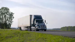 Modern black semi-truck with aerodynamic dry van trailer, highlighting its sleek design and fuel-efficient features on a scenic highway. Modern black semi-truck with aerodynamic dry van trailer, highlighting its sleek design and fuel-efficient features on a scenic highway.