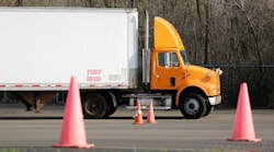Student truck driver practicing parking maneuvers in a commercial vehicle training yard, focusing on precision and skill development for CDL certification. Student truck driver practicing parking maneuvers in a commercial vehicle training yard, focusing on precision and skill development for CDL certification.