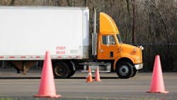 Student truck driver practicing parking maneuvers in a commercial vehicle training yard, focusing on precision and skill development for CDL certification. Student truck driver practicing parking maneuvers in a commercial vehicle training yard, focusing on precision and skill development for CDL certification.