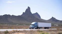 White semi-truck with reefer trailer driving on Arizona highway with mountain backdrop, symbolizing freight transport and long-haul trucking. White semi-truck with reefer trailer driving on Arizona highway with mountain backdrop, symbolizing freight transport and long-haul trucking.