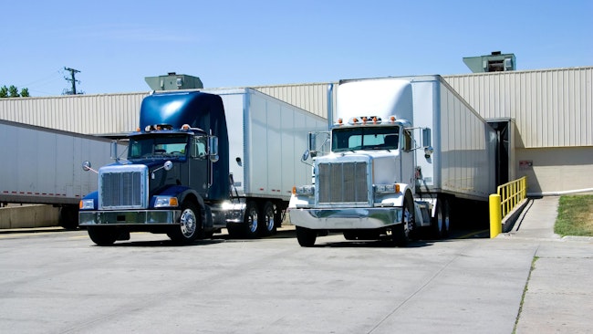Semi-trailer trucks loading and unloading at a warehouse dock, illustrating freight shipping, logistics, and fleet operations