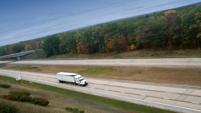 A white semi truck cruising on a highway, representing long-haul freight transportation