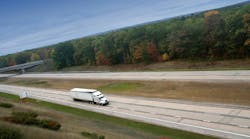 A white semi truck cruising on a highway, representing long-haul freight transportation A white semi truck cruising on a highway, representing long-haul freight transportation