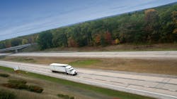 A white semi truck cruising on a highway, representing long-haul freight transportation A white semi truck cruising on a highway, representing long-haul freight transportation