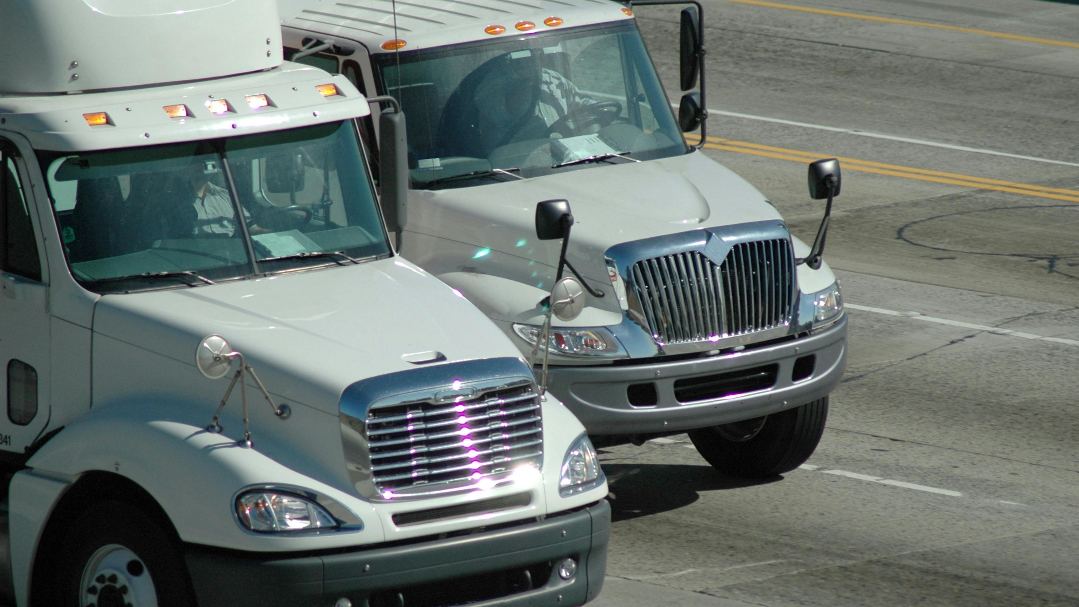 Delivery trucks traveling on a freeway in Southern California, approaching Los Angeles, illustrating regional freight transportation and logistics operations
