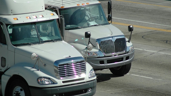 Delivery trucks traveling on a freeway in Southern California, approaching Los Angeles, illustrating regional freight transportation and logistics operations