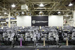 Rows of newly manufactured Detroit heavy-duty diesel engines lined up on the factory floor at the Detroit Manufacturing Plant under a large Detroit logo banner. Rows of newly manufactured Detroit heavy-duty diesel engines lined up on the factory floor at the Detroit Manufacturing Plant under a large Detroit logo banner.