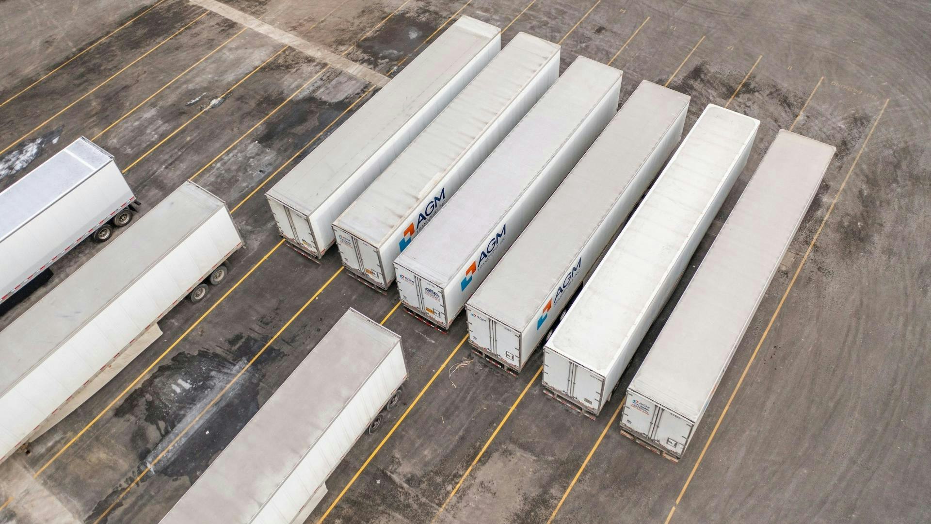 An aerial view of several white semi-trailers parked in a yard, illustrating the equipment density that BeyondTrucks aims to manage through AI-driven utilization.