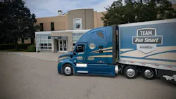A blue and yellow Albert Transport Freightliner Cascadia truck pulling a Team Run Smart trailer. A blue and yellow Albert Transport Freightliner Cascadia truck pulling a Team Run Smart trailer.