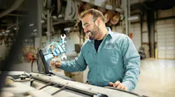 A truck maintenance technician using an advanced diagnostic device to analyze vehicle data in a garage bay, illustrating the application of AI for predictive maintenance and operational efficiency. A truck maintenance technician using an advanced diagnostic device to analyze vehicle data in a garage bay, illustrating the application of AI for predictive maintenance and operational efficiency.
