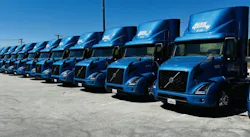 A line of blue Volvo VNR Electric Class 8 trucks deployed by 4 Gen Logistics.