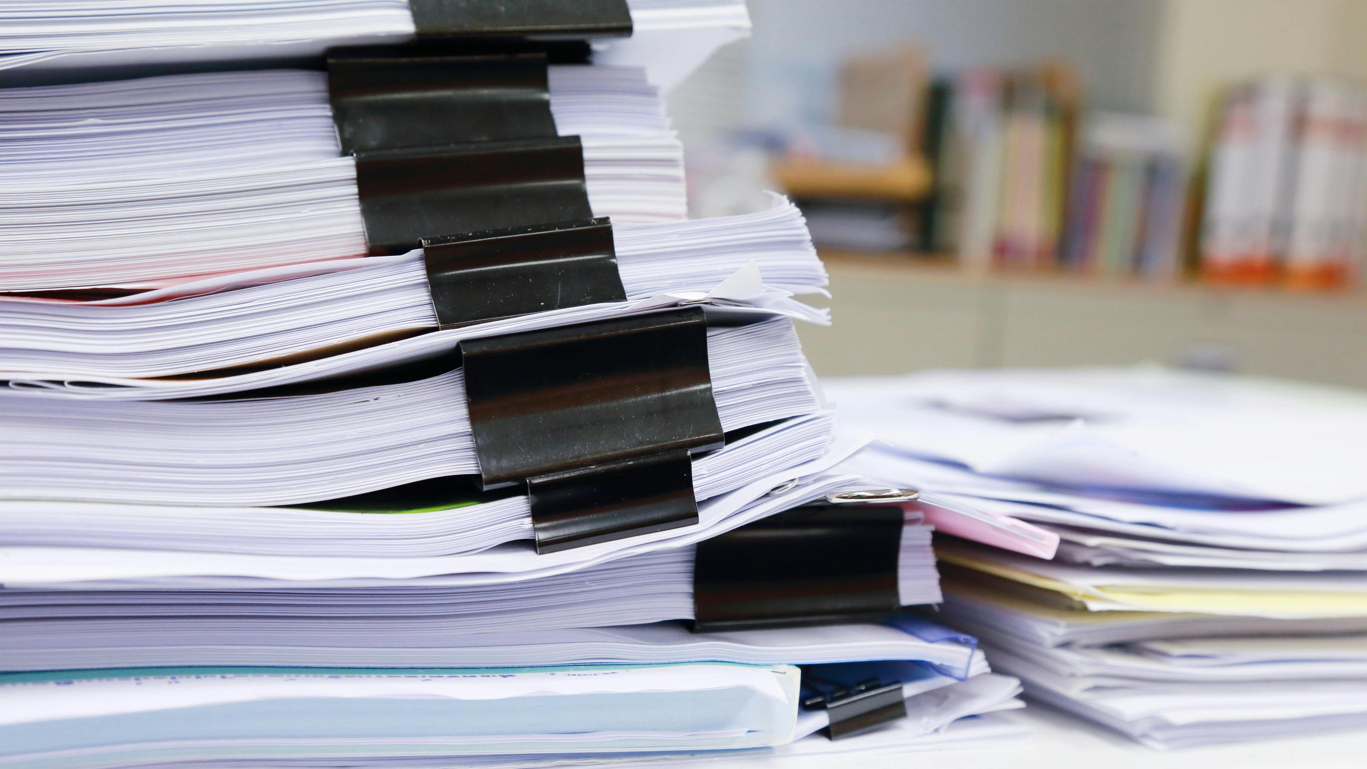 stack of paperwork in office reminiscent of regulatory filings