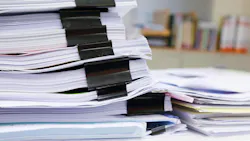 stack of paperwork in office reminiscent of regulatory filings