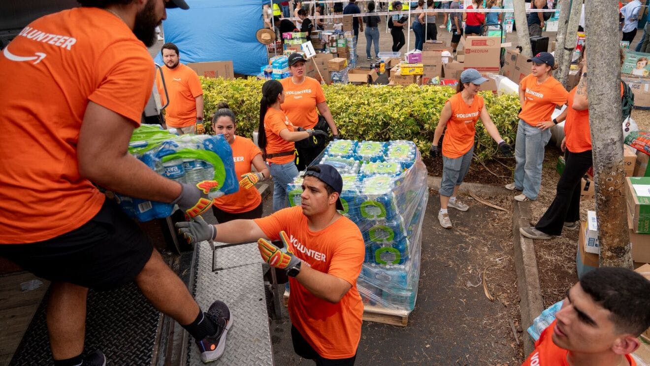 Volunteers from Amazon sort and pack emergency supplies for Venezuela earthquake relief alongside the nonprofit Global Empowerment Mission in Miami, Florida.