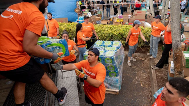 Volunteers from Amazon sort and pack emergency supplies for Venezuela earthquake relief alongside the nonprofit Global Empowerment Mission in Miami, Florida.