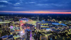 Aerial view of the Atlanta skyline at sunset with Mercedes-Benz Stadium, illuminated city streets, and surrounding buildings.