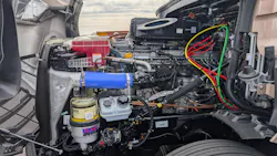 The open hood and engine compartment of a Fifth Generation Freightliner Cascadia revealing the heavy-duty Detroit Gen 6 diesel engine.