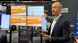 Hans Galland, CEO of BeyondTrucks, gestures toward digital fleet dispatch screens during a product demonstration at ATA MCE.